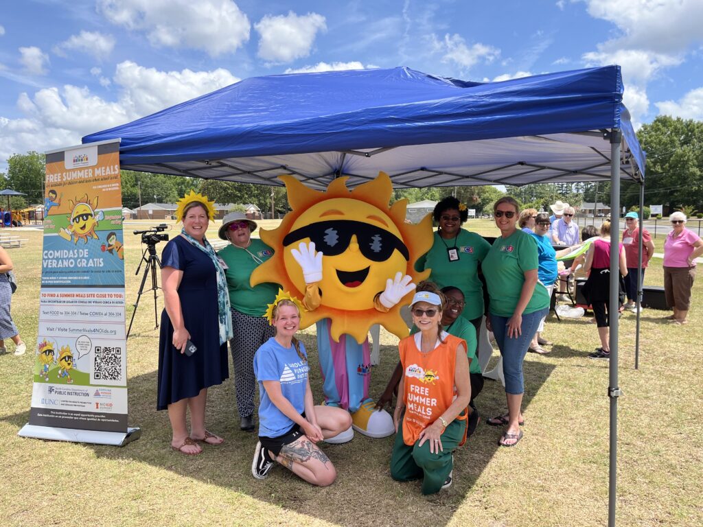 Mascot Ray F. Sun, posing with a team of NC Summer Meal Site Operators